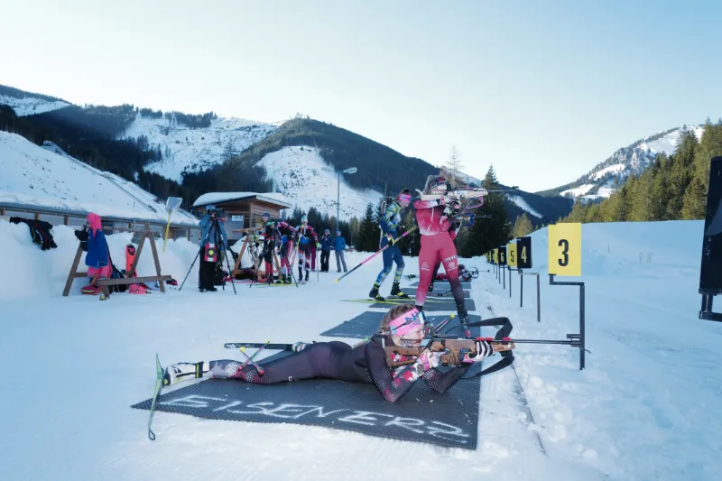 Biathlet im Winter beim liegenden Schießen.