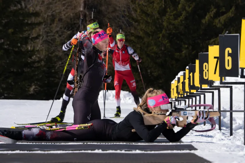 Biathlet im Winter beim liegenden Schießen.