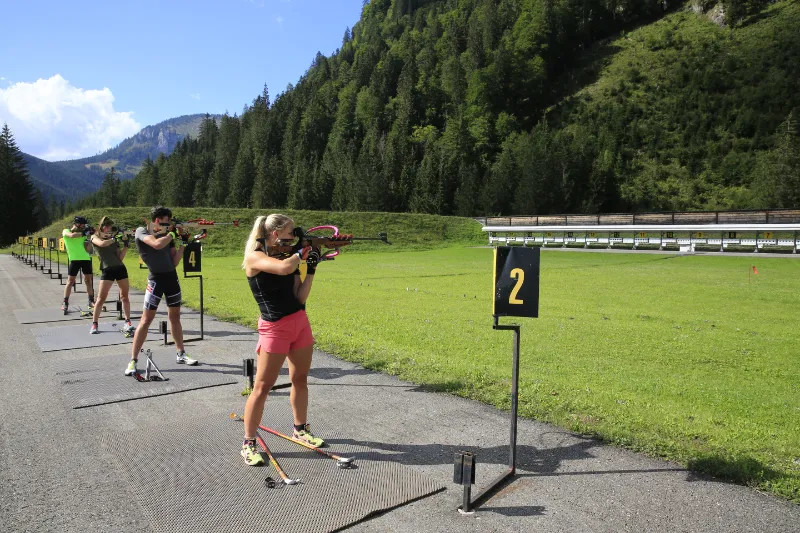 Vier Personen am Biathlon-Schießstand der Erzberg Arena im Sommer.