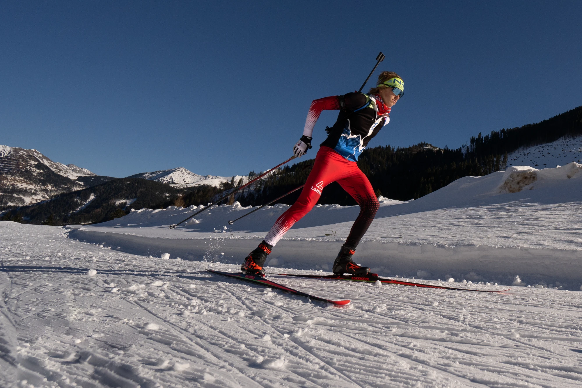 Biathlet in Aktion auf einer Langlaufloipe.