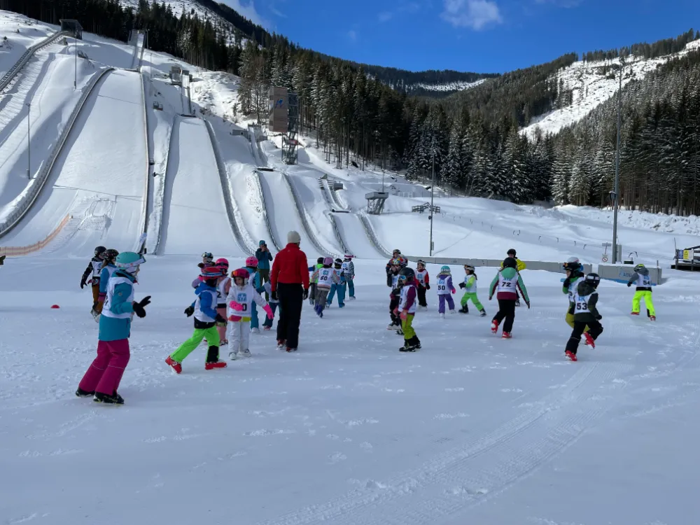 Kindergruppe mit Trainer bei den Schanzen in der Erzberg Arena im Rahmen der Nordic Camps.